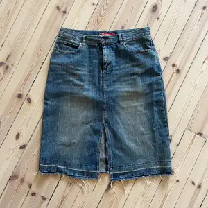 Säljer en cool jeanskjol från Only. Den är i en klassisk blå denimfärg och har en snygg slits framtill och bak. Kjolen har en rå kant nertill som ger en avslappnad look. Perfekt för både vardag och fest!