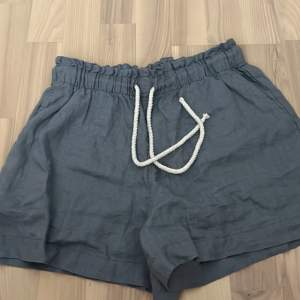 Mörkblå/grå linneshorts från H&M. Nästan oanvända i strl S. I gott skick. Med fickor och snörning i midjan.