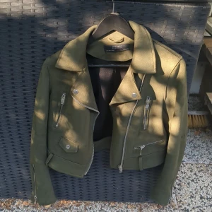 En mörk grön jacka - En mörk grön typ skin jacka från zara i storlek S den har två fläckar vid ryggen där inne på jackan annars är den oanvänd