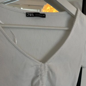 Topp med snöring - Gammal topp från Zara, har knyte framtill. Är väldigt kort och skulle kallat de en magtröja mer.