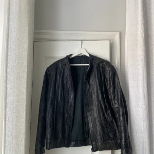 Vintage skinnjacka från Paris - Svart skinnjacka köpt i en vintagebutik i Paris. Har några skråmor pga vintage men överlag fint skick. Storlek saknas men passar allt ifrån xs-m. Säljer pga nyligen köpt en ny skinnjacka i samma stil :)
