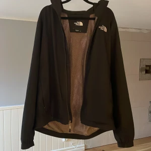 Svart vindjacka från The North Face - Säljer en svart vindjacka från The North Face då den är för stor mig. Är perfekt nu till hösten då det blir lite kyligare. Den är i bra skick förutom att the north face loggan på baksidan är lite skadad (kolla tredje bilden). Men annars är det inga skador och nypris är ungefär 2000 kr så tveka inte!!!!!