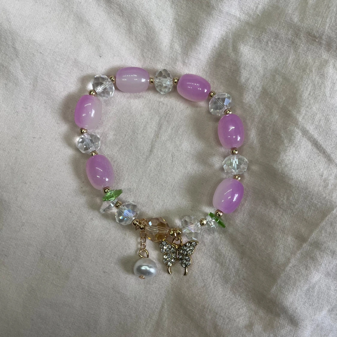Lila och pärlarmband med berlocker