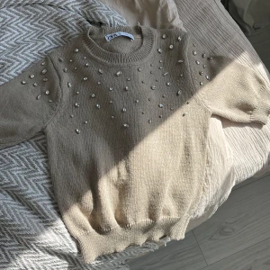 NY SKICK! Stickad tröja med pärlor - Stickad tröja med pärlor från märket Zara. Tröjan är i nyskick, säljer då den inte kommit till användning.  Tröjan finns ej längre i butik. 