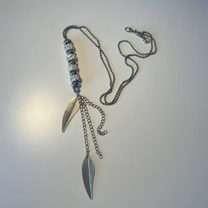 Stort långt silver fjäder halsband - Ett otroligt snyggt statement halsband som passar perfekt nu till höstern, fjädrar och stenar som får detta unika halsbandet att sticka ut från mängden. Små revor här och där men annars skulle jag vilja säga att den är i bra skick. 😍🫶
