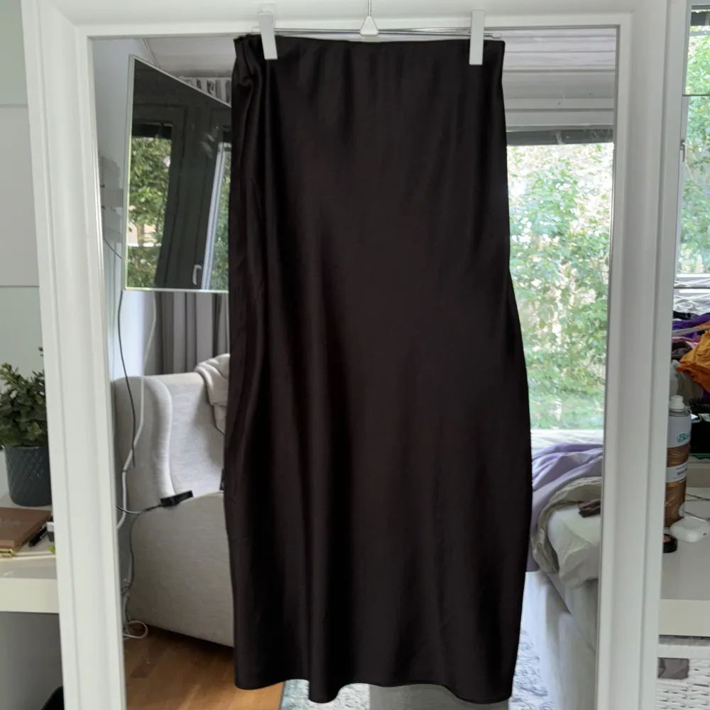 Svart satinkjol från chqiuelle. Går ner till mitten på vaderna (jag är 167cm). Använd enstaka gång. . Kjolar.