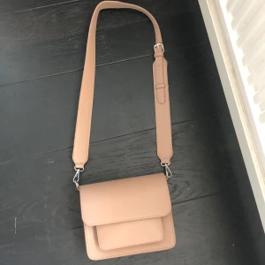 Väska   - Superfin brun/beige väska. Aldrig använt väskan. Det går att byta ut bandet på väskan. Ny pris 700. Köparen står för frakt om man inte vill mötas upp i Stockholm city. Kontakta gärna om ni har några fler frågor!🥰