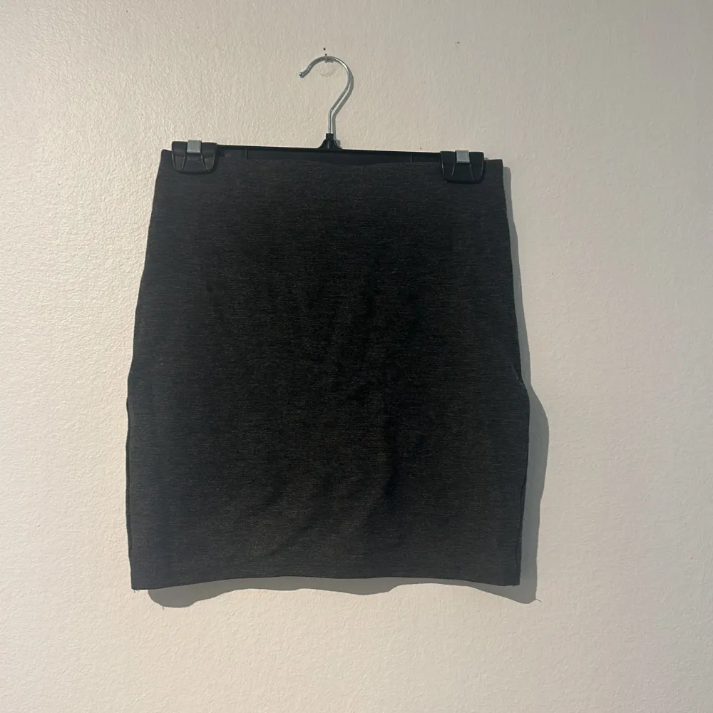 Säljer en stilren svart kjol i normal passform. Perfekt för både vardag och fest! Kjolen är i ett mjukt och bekvämt material, Den har en enkel design utan mönster bara liten detalj framtill, vilket gör den lätt att matcha med olika toppar och accessoarer. Oanvänd, resår längst upp💕. Hameet.