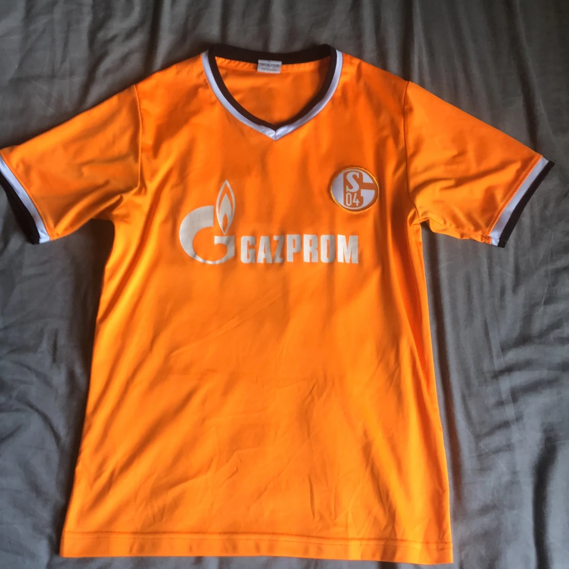 Orange fotbollströja med Gazprom-logga