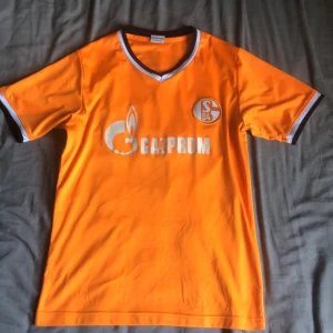 Orange fotbollströja med Gazprom-logga - Säljer en Schalke 04 tröja. Fint skick och knappt använd! Pris går att diskuteras!