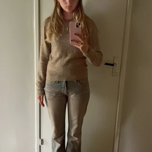 Beige stickad tröja från H&M - Säljer en supermysig beige stickad tröja från H&M. Perfekt för höst och vinter med sin varma och bekväma känsla. Tröjan har långa ärmar och en klassisk rund halsringning. 🍁