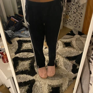Svarta mjukisbyxor med vita ränder - Säljer ett par svarta adidas mjukisbyxor. Dem är i strl 38 men passar även 36-34.