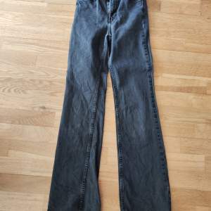 Säljer ett par snygga svarta bootcut jeans från H&M. De är högmidjade och gjorda i denim, vilket gör dem både bekväma och stiliga. Perfekta för både vardag och fest!