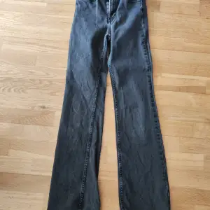 Säljer ett par snygga svarta bootcut jeans från H&M. De är högmidjade och gjorda i denim, vilket gör dem både bekväma och stiliga. Perfekta för både vardag och fest!