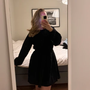 Svart klänning - Svart klänning från H&M i storlek S (passar även M). Öppen i ryggen med en knytning samt resor i midjan som gör den mer figursydd!  || Aldrig använd! 