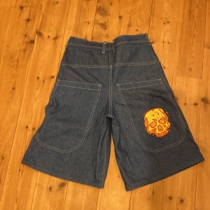 Jeansshorts med dödskallebroderi - Är inte säker på om jag ska sälja! skit snygga självgjorda JNCO liknade jorts. Spendera mycket tid på dom här shortsen så det förklarar priset. 