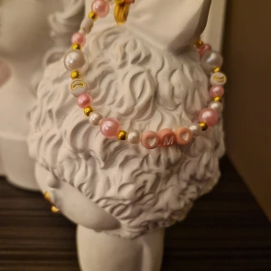 Pärlarmband med bokstaven M  - Sött pärlarmband med bokstav M omgiven av två hjärtan.   Omkrets cirka 20 cm 