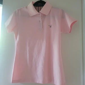 Pikétröja Rosa tjej stl.M Pike - Superfin rosa piketröja. Stl.M slim modell Bredd ca 38cm, längd ca 59cm. Ny!! Aldrig använd Inga byten -köpt är köpt - återkom med frågor eller fler bilder.