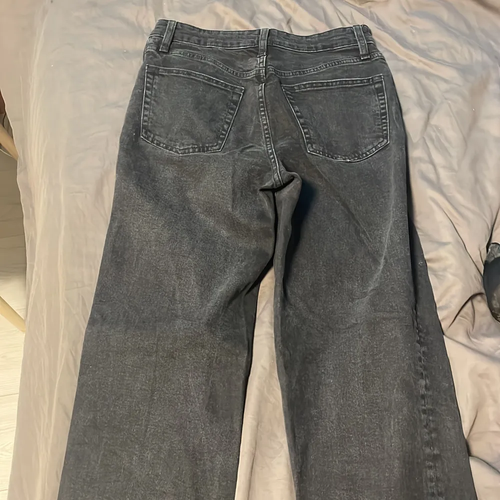 Säljer ett par jeans från H&M Divided i storlek 36. De har en cool, sliten look med fransiga kanter och en knappgylf. Perfekta för en avslappnad stil!. Jeans & Byxor.