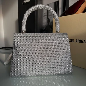 Väska  - Säljer denna glittriga väska då den tyvärr inte kommer till användning, liten och smidig, man får även med ett långt band🥰 Pris går att diskuteras! 