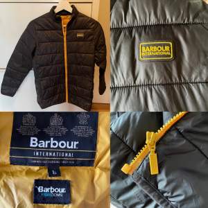 Äkta unisex Reed Quilt Barbour jacka i välvårdat skick. Från rökfritt och djurfritt hem. Storlek 10-12 år.  Svart med orangegult foder. Köpt på Kidsbrandstore. Nypris 1200:- säljes för 300:-