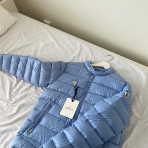 Ljusblå Moncler dunjacka - Aldrig Aldrig använd ute bara testad Size M  NFC chip på loggan Har en liten fläck som fanns på jackan när den kom med(bild finns) 