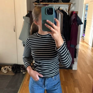Svart/vit randig ribbad långärmad  - Är barnstorlek, men skulle säga att den är som en xs/xxs. Lite kortare modell i ärmarna. Går att få på köpet vid köp av annan tröja. 