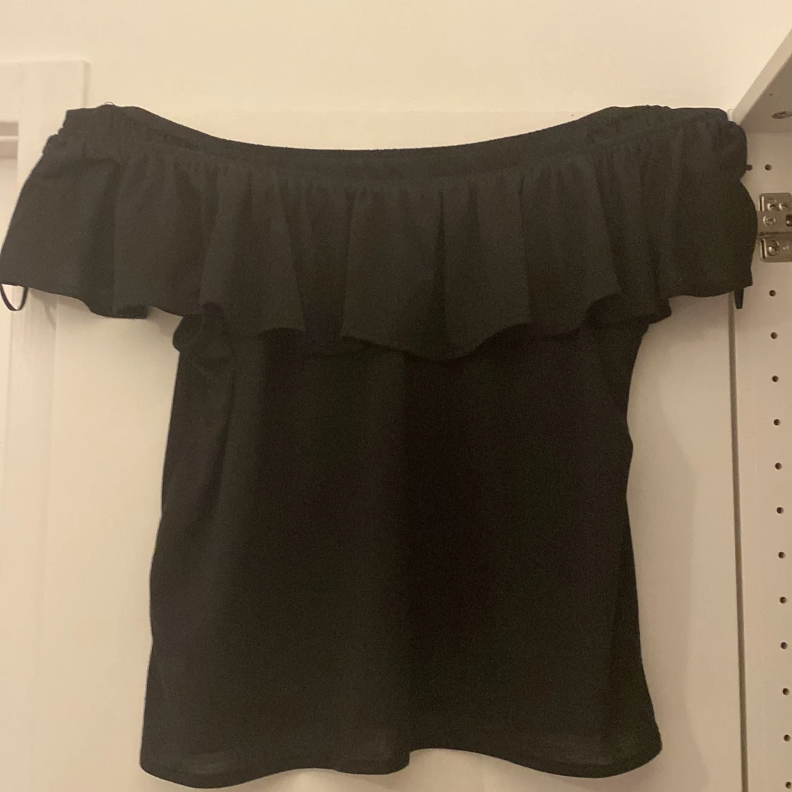 Svart offsholder tröja med volang 