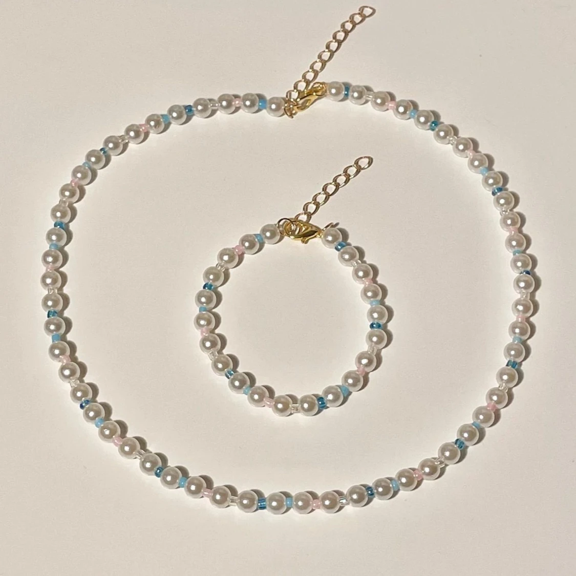 Pärlhalsband och armband med blå detaljer