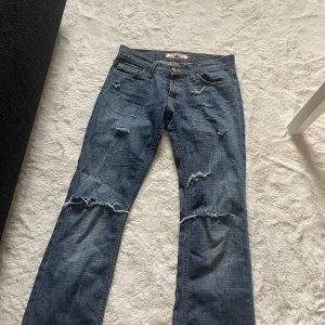 Jätte snygga boot cut jeans med hål - Jätte fina boot cut jeans med hål. De är low waist. Säljer då de var alldeles för små för mig.  Säljer billigt då dragkedjan har gått sönder men det är enkelt att fixa. Innerbenslängd: 72cm Midjemått rakt över: 33cm Skriv om ni undrar något ❤️