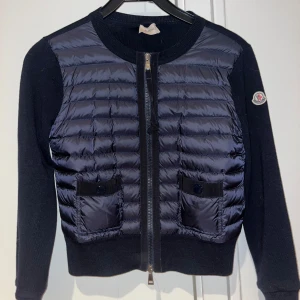 Moncler cardigan tricot (Dam) - Moncler jacka i dammodell i nyskick. Mörkblå i färgen med 2st fickor & 2 dragkedjor. Endast använd två gånger. Inköpt på Farfetch för 6000kr. Kod för äkthet finns på sista bilden. Pris kan diskuteras vid snabb affär. Storlek XS men passar även en S