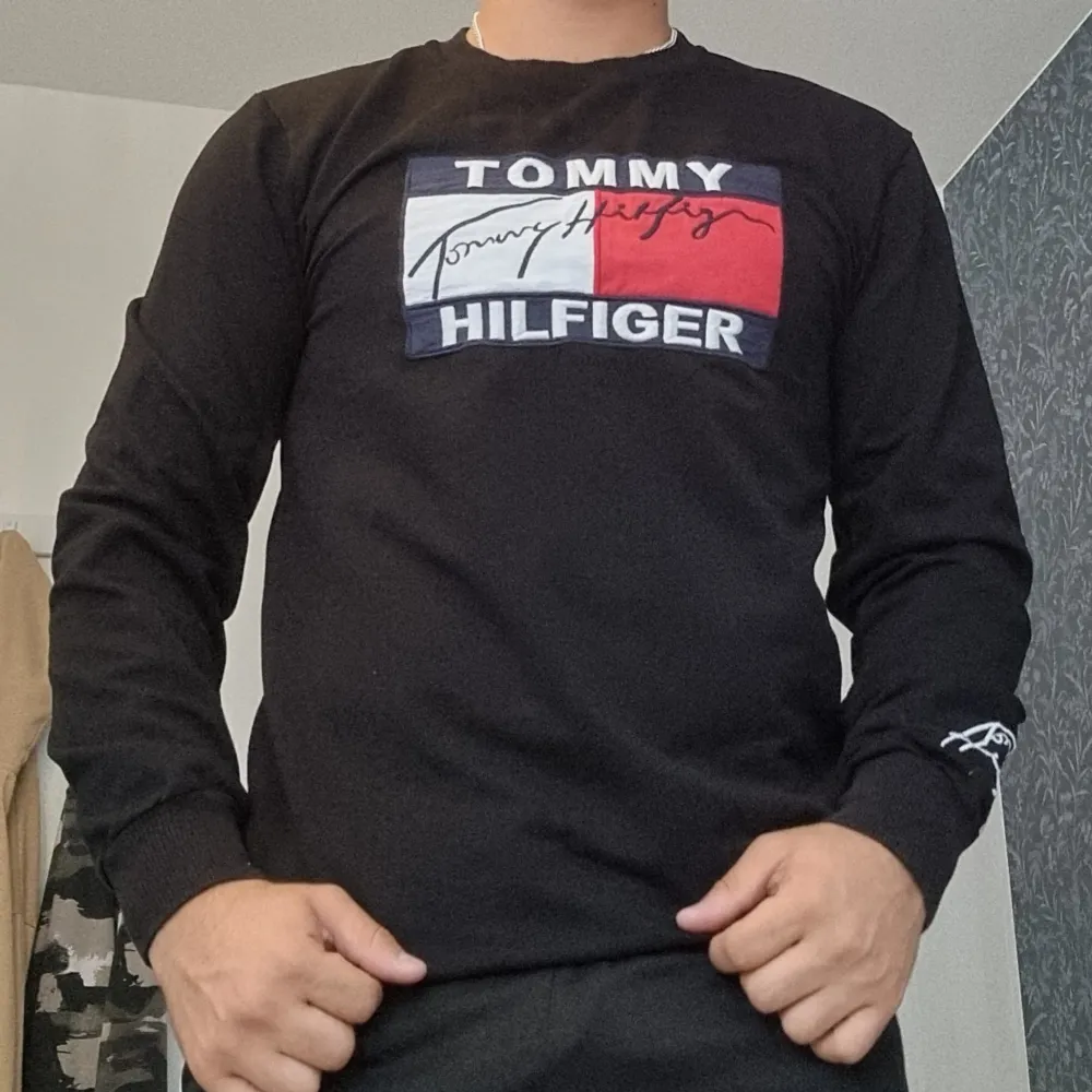 Säljer en snygg svart långärmad tröja från Tommy Hilfiger.. Tröjan är i storlek m och passar perfekt för både vardag och fest. Den är i bra skick och superbekväm att ha . Hoodies.