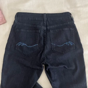 Lågmidjade jeans - Mörkblå jeans med detaljer på bakfickorna, väldigt sköna och stretchiga. Står storlek 4, passar 36/38