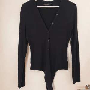 Mjuk body från abercrombie & fitch nyskick - Svart body med knappar från Abercrombie & fitch. Mycket mjukt material. Oanvänd 