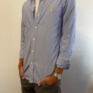 Randig Ralph Lauren Skjorta - Säljer denna blåvit-randiga skjorta från raffe. Funkar perfekt under en tröja eller bara som den är. Skick 10/10 inga som helst defekter. Sparsamt använd. Orgpris ligger på 1695. Tveka inte att höra av dig vid frågor eller funderingar!