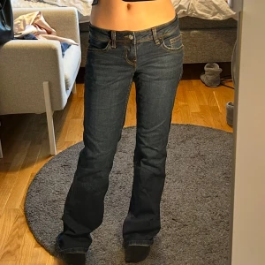 Lågmidjade bootcut jeans - Mörkblå Lågmidjade bootcut jeans med orange/bruna sömmar med snygga detaljer på bakfickorna! Aldrig använda bara provade. Säljer för de tyvärr inte kommit till användning 💞💞💞 helt slutsålda i storleken på hemsidan 