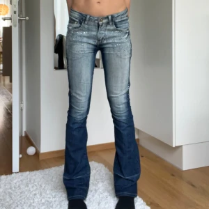 LowBoot glitterdetaljerade jeans😍 - Säljer dessa ursnygga glitterdetaljerade LowWaist BootCut jeansen i storlek w26💕Fint skick förutom att några diamanter trillat av(se bild 3). Jag är 166cm. Skriv för fler frågor!🥰