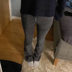 Grå jeans med bootcut - Säljer ett par grå lowwaist/midwaist jeans med bootcut. De är lite slitna där nere och så har jag klippt hål på insidan som jag haft snöre i men är inget som syns! 