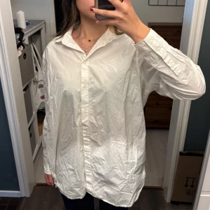 Vit skjorta från H&M - Säljer en klassisk vit skjorta från H&M i storlek M(oversized). Skjortan har en normal passform med långa ärmar och knappar framtill. Perfekt för både vardag och fest! Lite skrynklig men i bra skick.