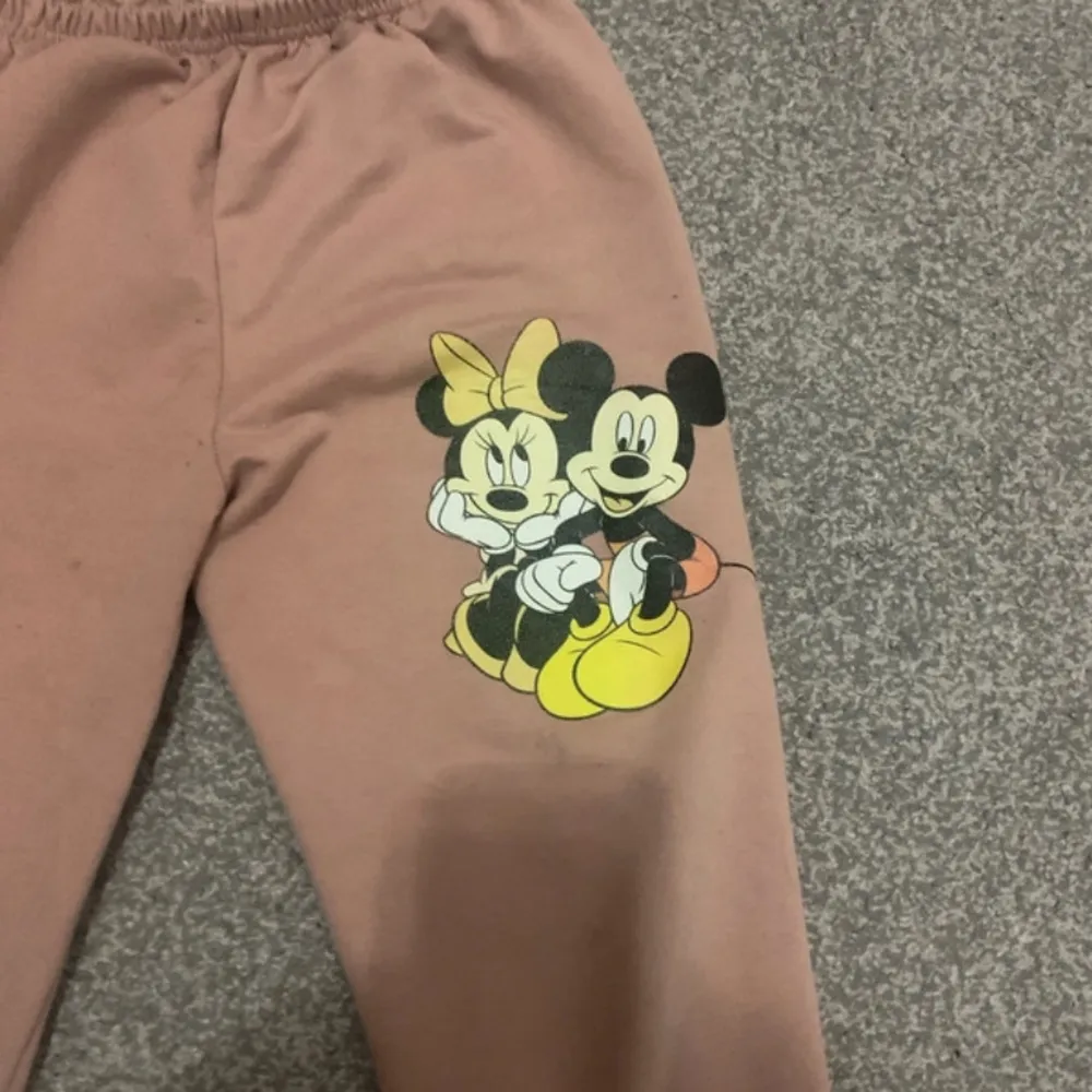 Jag säljer en rosa mickey mouse set för barn som är med en ritning av mickey mouse på byxorna och hoodie. Den är skön och varm och jette snygg för barn. Den passar för barn som är 10,9 år eller yngre. Jeans & Byxor.