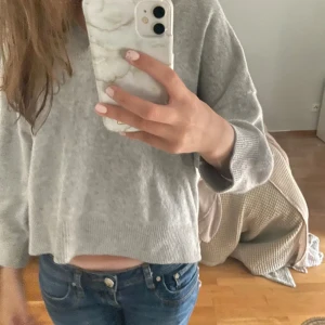 Grå stickad tröja - Säljer en supermysig grå stickad tröja med v-ringning. Den är perfekt för höst och vinter och har långa ärmar. passar perfekt till jeans eller kjol. Perfekt för en avslappnad stil!