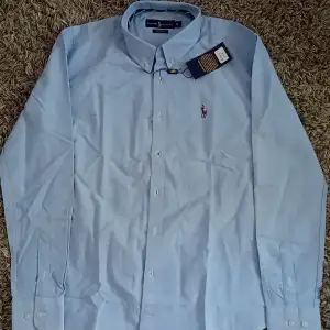 Oanvänd Ralph lauren skjorta i storlek M, slim fit. Skicket på skjortan är 10/10, nypris är 1499 men säljer den för endast 699. Hör av dig vid minsta fråga eller fundering.