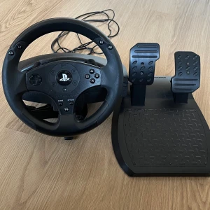 Playstation styr ratt Thrustmaster - Styrratt från playstation. Fungerar fint, dock spännat man använder för att sätta fast ratten behövs lagas men allt annat fungerar fint! Fungerar till ps4 och ps5