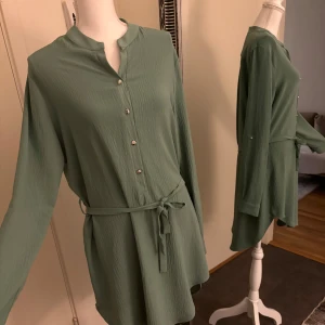 Skjort klänning  - Färgen grön, den skjortan går ner till mina knän både bak och framsida om man vill va modest. Storlek är 44 men skulle säga att den passar 34-44. 