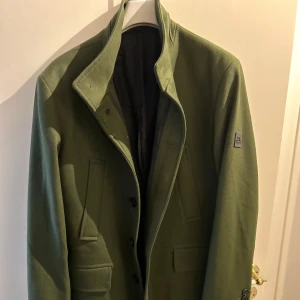 J Lindeberg kappa herr - Snygg herr kappa från J Lindeberg. Upplevs mycket mer grön på bilden men är en dovare nyans grön i verkligheten, militärgrön skulle jag säga. Endast använd en kväll. 