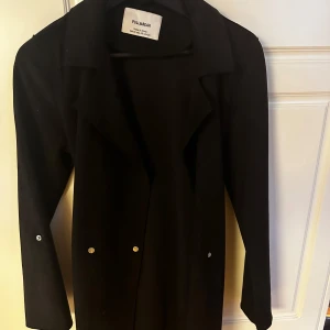 Svart kappa  - En tunn fin vår kappa från Pull and bear i storlek xs jätte fint skick. Köpt för 399kr säljer för 200kr