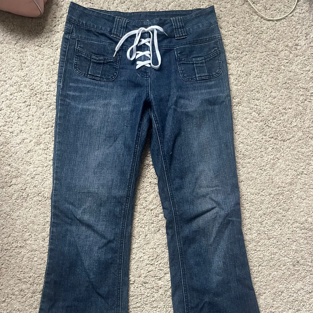 Lågmidjade bootcut jeans med knytning i midjan. Jeansen har inga fickor på baksidan. Jag är 170 och de är lite förkorta för mig, samt lite breda.  Skulle säga att de passar en storlek M.. Jeans & Byxor.