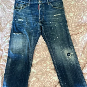 DSQUARED2 Jeans - Säljer dessa dsquared2 jeansen för killar. Dom ser ut i helt nyskick förutom en liten defekt där bak vid bakfickan men något som ej syns när man har på dom. Dom är i en blå färg och har använts fåtal gånger