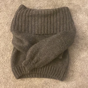 Mörk grå off shoulder tröja - Denna tröja är en väldigt varm och gosig tröja! Köpt förra året! Väldigt fin på. Dock är den lite liten i storleken! Jag köpte den för runt 399kr tror jag, men säljer den för 110kr!