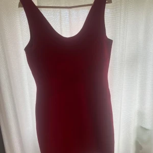 Röd ärmlös klänning - Säljer en snygg röd ärmlös klänning som är perfekt för festliga tillfällen. Klänningen har en tight passform och är gjord i ett mjukt material som känns skönt mot huden. Den är enkel men elegant och kan lätt stylas upp med smycken och klackar. Perfekt för en utekväll eller en speciell middag! 💃